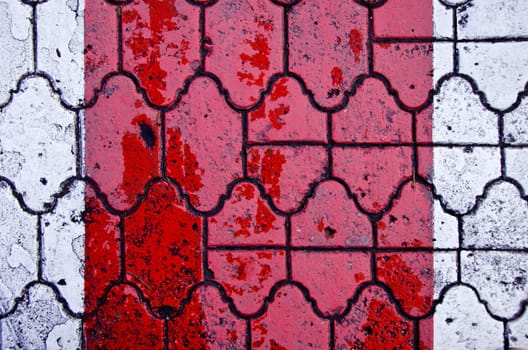 Background of red color crosswalk on road paved by decorative tiles.