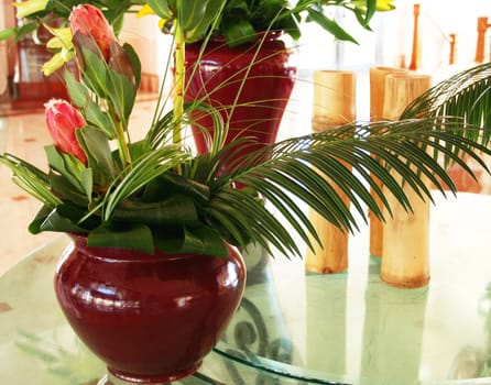Beautiful decor with two vases with flowers and bamboo on the table