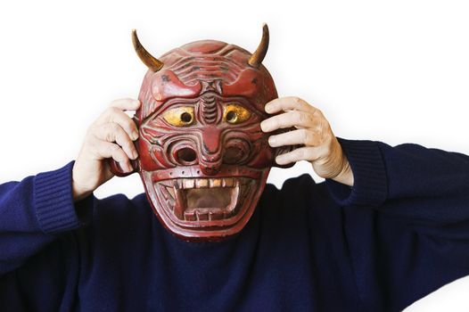 person wearing a blue sweater holding up a red devil mask
