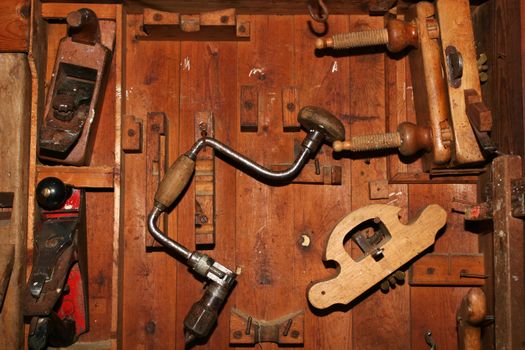 Very old and worn woodworking tools in worn down cabinet