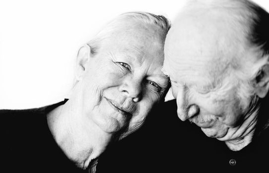 Close-up of senior couple embracing focuses on smiling woman