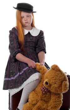 Travelling redhead girl become sad and now she is sitting on her trunk with the toy bear