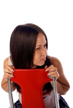 Dark haired young woman is sitting on the read modern chair