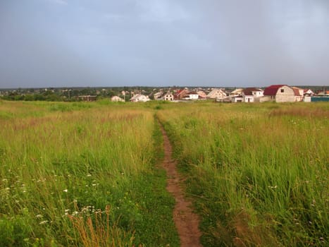 Grassland landscape with foot-path before storm, Russia