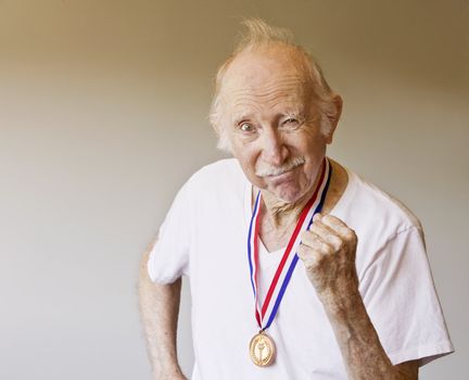 Senior Citizen Posing with a Gold Medal