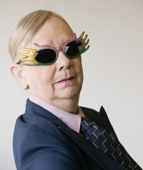Senior woman in a baggy man's suit wearing funny glasses