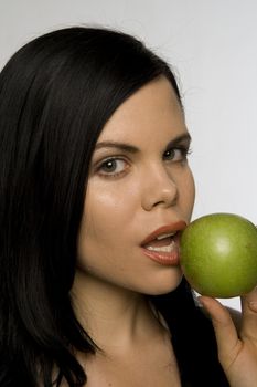 Attractive woman posing with delicious  looking green apple. Use for "health," "healthy eating," "temptation" etc.