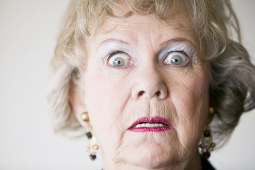 Close-up of a senior woman with a horrified look on her face.