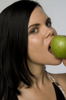 Attractive woman posing with delicious  looking green apple. Use for "health," "healthy eating," "temptation" etc.