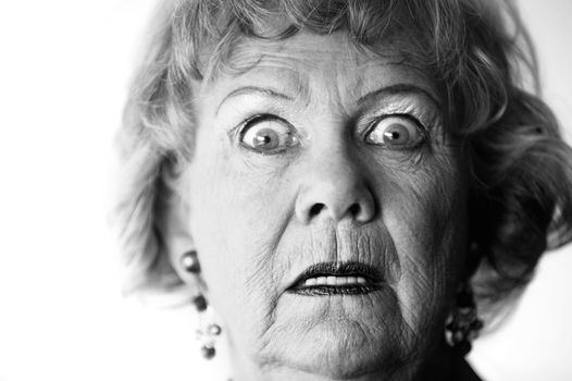 Close-up of a senior woman with a horrified look on her face.