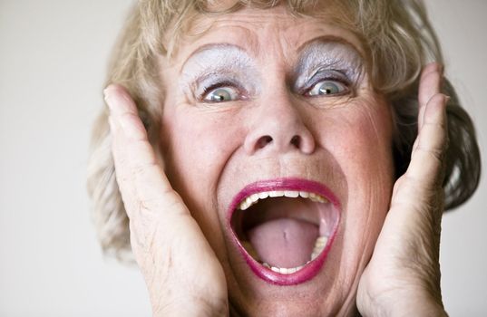Close-up of a senior woman with her mouth open screaming.