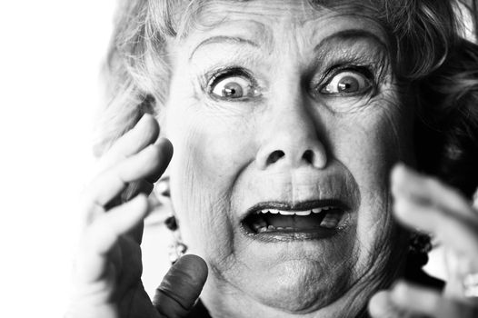 Close-up of a horrified senior woman with her mouth open.