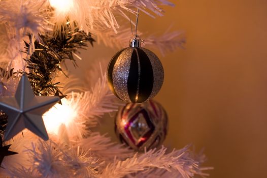 a close up shot of a bauble hanging from a christmas tree.