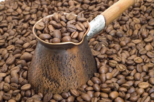 Turkish coffee pot on a background of coffee grains.