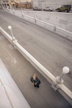 Wide shot from above of woman on a sidewalk