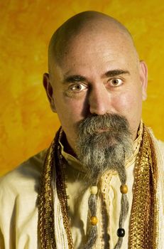 Funny bald guru with a long beaded beard.