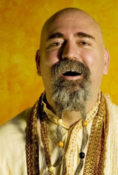 Funny bald guru with a long beaded beard.