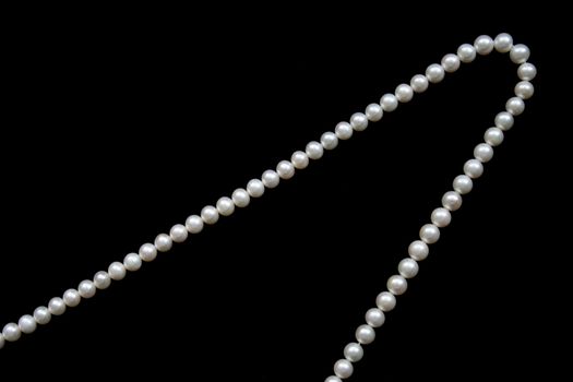 White pearls on the black velvet  background