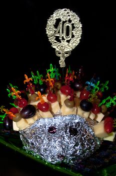 hedgehog made from sticks with delicious food - cheese, olives, tomatoes, grapes