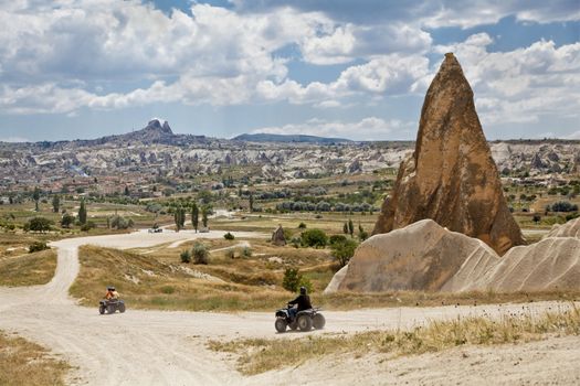 Landscape of dirt riding in Cappadocia on the outskirts of Goreme with Uchisar on the hill backdrop, horizontal, crop margins with negative space