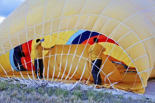 Roadies inside a yellow hot air balloon making ready for a flight in Cappadocia Turkey, horizontal landscape with crop margins and free space