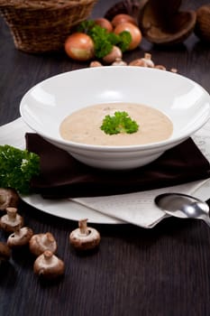 fresh chmapignon cream soup with parsley decorated on wooden table