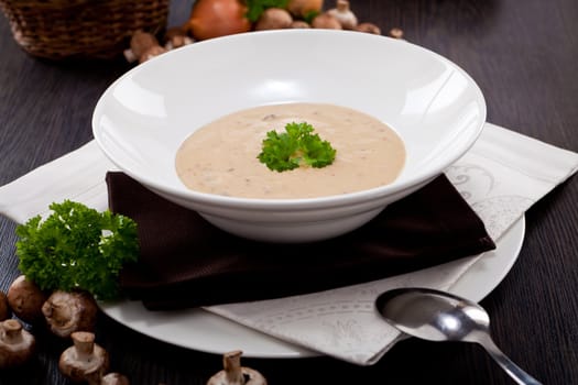 fresh chmapignon cream soup with parsley decorated on wooden table