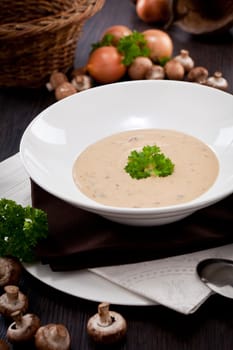 fresh chmapignon cream soup with parsley decorated on wooden table