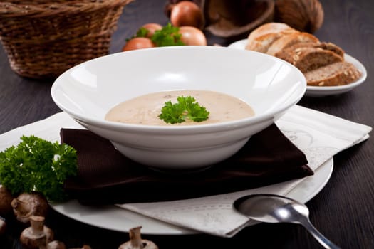 fresh chmapignon cream soup with parsley decorated on wooden table