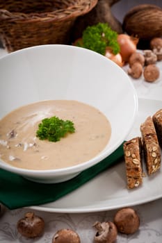 fresh chmapignon cream soup with parsley decorated on wooden table