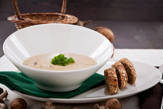 fresh chmapignon cream soup with parsley decorated on wooden table