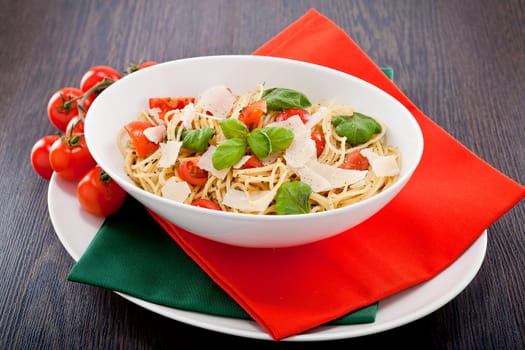 fresh tasty pasta spaghetti with tomatoes parmesan and basil on table