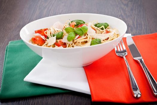 fresh tasty pasta spaghetti with tomatoes parmesan and basil on table