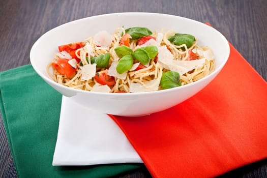 fresh tasty pasta spaghetti with tomatoes parmesan and basil on table