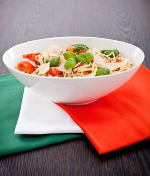 fresh tasty pasta spaghetti with tomatoes parmesan and basil on table