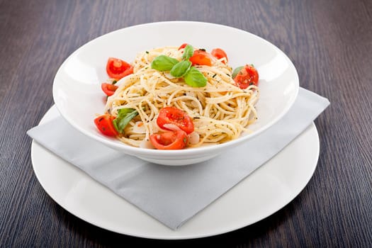 fresh tasty pasta spaghetti with tomatoes parmesan and basil on table