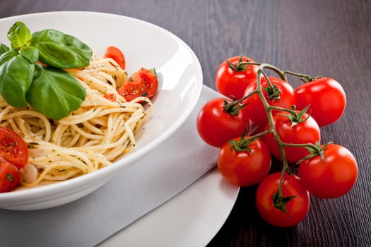 fresh tasty pasta spaghetti with tomatoes parmesan and basil on table