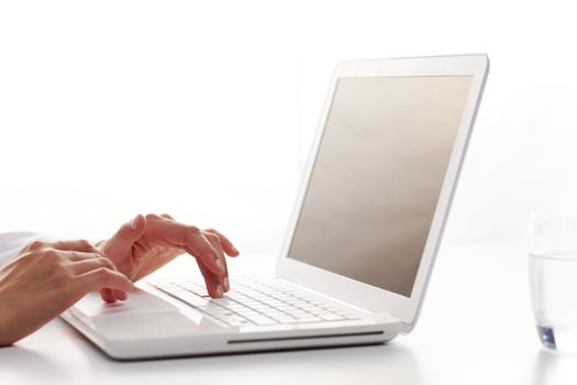 Female hands typing on a white computer keyboard