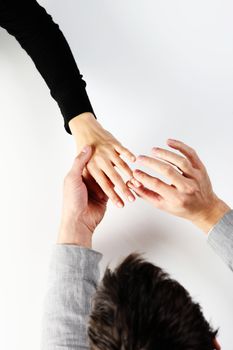 man putting a  ring with a brilliant on a female hand, top view