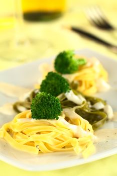 Broccoli on fettuccine with bechamel sauce and ground pepper (Selective Focus, Focus on the front of the first broccoli)