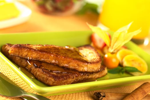 French toast with maple syrup and fruits (Selective Focus, Focus on the front of the upper slice) 