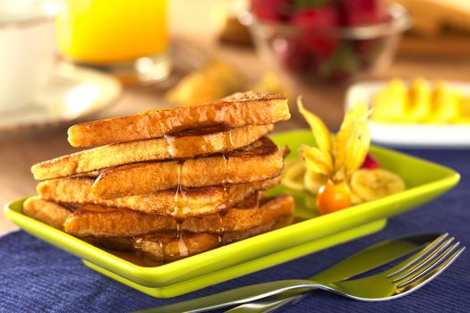 French toast with maple syrup and fruits (Selective Focus, Focus on the front of the upper slice) 