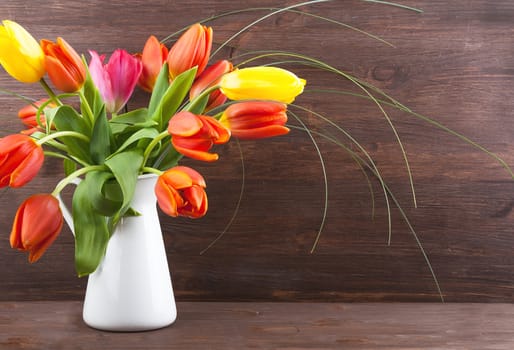 Bouquet of colorful tulips on dark wooden background