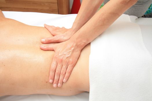 A female masseur giving a back massage