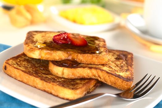 French toast with maple syrup and strawberry (Selective Focus, Focus on the front of the upper slice) 