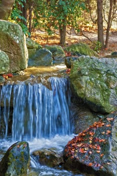 Blue water spring and red leaves in autumnal forest