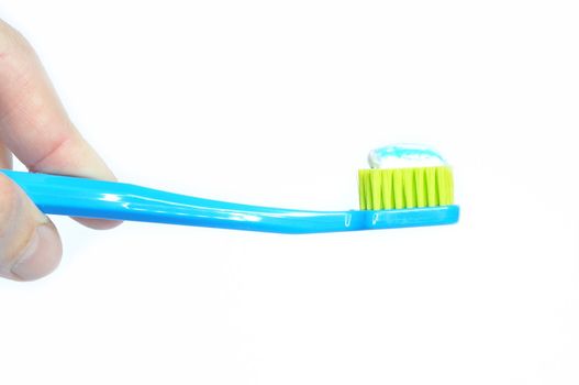 Toothbrush and toothpaste in hand, isolated
