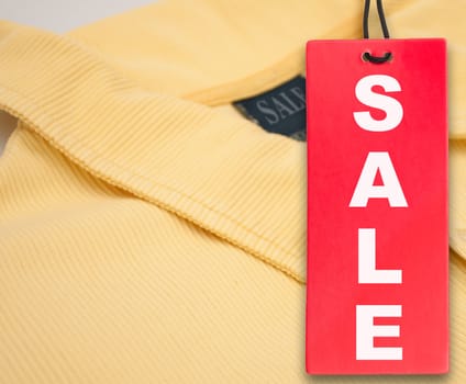 Hanging Red Sale Tag and Yellow Polo Shirt