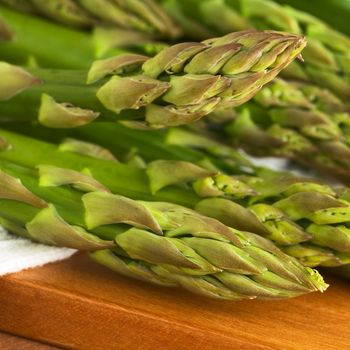 Closeup of raw green asparagus heads (Selective Focus, Focus on the two asparagus heads in the front)