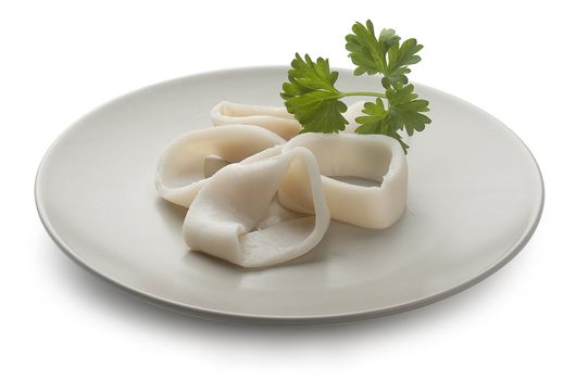 Some raw rings of squid with parsley on the plate
